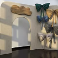 Beige Arched Storefront With Wooden Plaque and Multiple Colored Bows Green Blue Gold Gray Silver