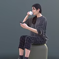 Woman Sitting On Round Stool Using Mobile Phone And Drinking Coffee In Casual Outfit