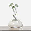 Small Bonsai Plant With Green Leaves In Natural Stone Shaped Pot On Wooden Table