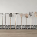 Garden Tools Collection Arranged Against White Wall With Brick Base And Wooden Floor