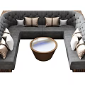 L shaped Gray Public Seating With Brown And White Cushions And Round Wooden Table