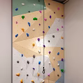 Colorful Indoor Climbing Wall With Multicolored Holds And Safety Rope