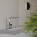 Modern Kitchen Sink With Chrome Faucet On Marble Countertop And Green Plant