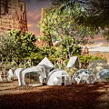 Unique Campsite With Various Shaped Tents Surrounded By Trees And Red Cliffs At Dusk