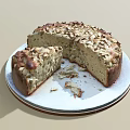 Freshly Baked Round Cake With Nut Toppings On White Plate And Sliced Piece
