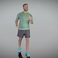 Man Wearing Green T-Shirt Gray Shorts And Blue Sneakers Standing Casually