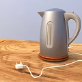 Silver Electric Kettle on Wooden Tabletop with Power Cord and Plug
