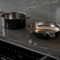 Sturdy Black Cooking Pots and Frying Pan on Sleek Marble Kitchen Counter