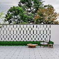 White Perforated Lattice Feature Wall with Greenery Outdoor Chair Coffee Table and Gray Tiled Floor