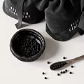 Black Ceramic Bowl Filled With Seeds Near Wooden Spoon And Fabric Bags