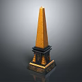 Tall Golden Topped Obelisk With Black Base And Ornate Decorative Elements