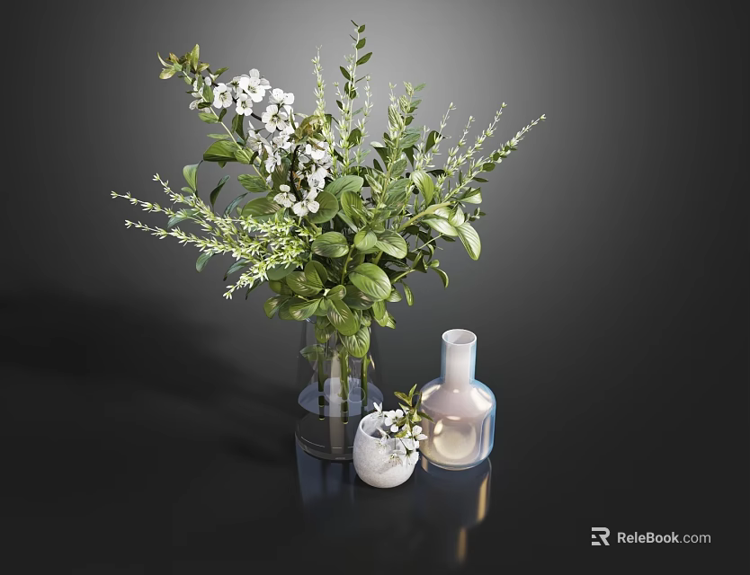 White Blooms and Green Leaves in Glass Vase with Small Decorative Vases on Dark Surface 3d model 