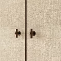 Elegant Brass Door Handles Mounted On Beige Textured Fabric Cabinet Panels