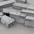 Broken Concrete Blocks Scattered On Ground With Cracks And Metal Fasteners