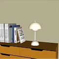 Minimalist Table Lamp Emitting Soft Light On Wooden Bookshelf With Books
