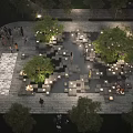 Water Fountain in Evening Public Square with Illuminated Lights Green Trees and People