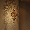 Ornate Golden Chandelier With Intricate Filigree Design Casting Beautiful Shadow Patterns On Wall