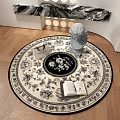 Round Rug Featuring Black Floral Patterns Open Book And Small Statue On Wooden Floor