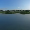 Serene Natural Landscape With Calm Deep Blue Lake Lush Green Islets And Bright Clear Sky