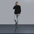 Man In Black Shirt And Light Blue Jeans Talking On Phone Against Gray Wall