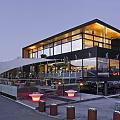 Modern Building Exterior With Large Glass Windows Black Walls And Terrace Red Lights Outdoor Seating
