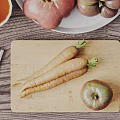 Fresh Vegetables Including Tomatoes and Carrots on Wooden Table with Plate and Cutting Board