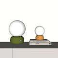Modern Minimalist Table Lamps with Spherical White Shades and Green Yellow Bases on Books