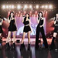 Women Performing on Stage with Microphones in Black Outfits and Stage Lights