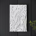 White Textured Sculptural Wall Decor on Dark Background With Green Plant Accent