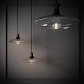 Three Modern Glass Pendant Lights With Black Base Hanging In Dark Background Emitting Soft Light 3d model