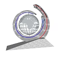 Circular Globe Ring Sculpture With Cherry Blossom Trees Lawn Flower Beds And Street Scene