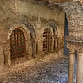 Cartoon Scene of Ancient Stone Arches with Carved Pillars and Wooden Doors in Medieval Courtyard