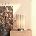 Pleated Table Lamp on Wooden Tabletop with Beige Wall and Golden Flower Branches