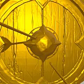 Golden Circular Sculpture Carving With Intricate Patterns And Arrow Detail