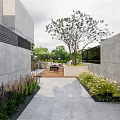 Modern Courtyard Garden Design With Wooden Deck Gray Sofa Fire Pit And Large Green Plants