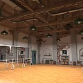 Bright Fitness Dance Studio with Wooden Floor Barre Green Pendant Lights and Exposed Brick Walls