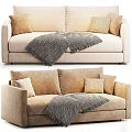 Cozy Beige Two Seater Sofa With Textured Pillows And Knit Blanket