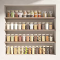 Organized Kitchen Shelves With Glass Spice Jars Containing Various Grains And Spices