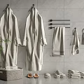 Soft Towels And Cozy Robes Arranged With Slippers On Gray Tiled Wall