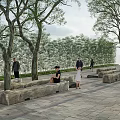 Stone Outdoor Chairs in Park Setting with Trees Brick Pavement and People Around