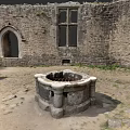 Stone Detached Villa Exterior With Arched Doorway Large Windows And Circular Well