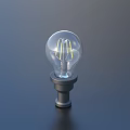 Transparent Light Bulb With Yellow Filament And Metal Base On Dark Background