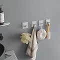 Stylish Bathroom Accessories on Gray Wall with White Hooks Bath Sponge Towel and Wooden Brush