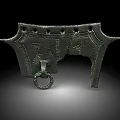 Ancient Bronze Artifact Featuring Intricate Carvings Decorative Holes And Hanging Ring
