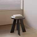 Round Three Legged Wooden Stool With Books On Indoor Wooden Floor Near Window