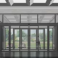 Modern Glass Entrance With Automatic Doors Reflecting Green Lawn And Trees