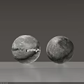 Pair of Spherical Floor Lamps with Moon Surface Texture Illuminated and Dimmed on White Tabletop