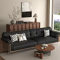 Black Leather Sofa and Round Wooden Coffee Table Set with Patterned Pillows and Books