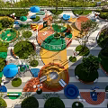 Colorful Children's Play Area With Interactive Play Structures And Green Plants
