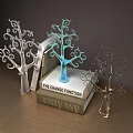 Tree Shaped Decorative Ornament Set with Silver Blue Dark and Stacked Books on Wooden Table